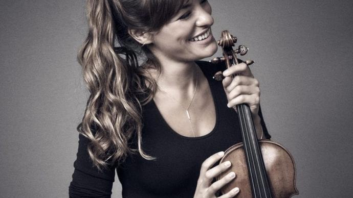 Nicola Benedetti holds her violin, smiling away from the camera