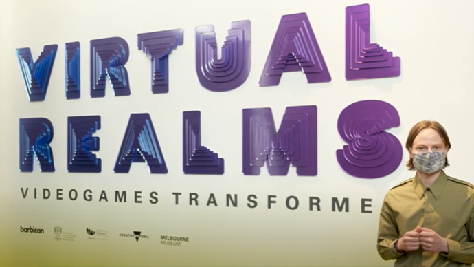 a man stands in front of a wall saying virtual realms