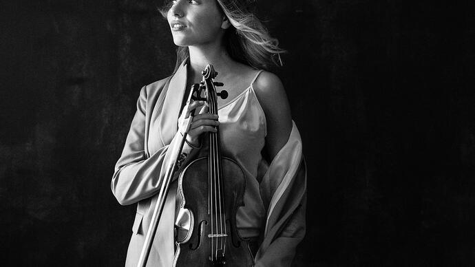 Black and white photo of Diana Tishchenko holding her violin