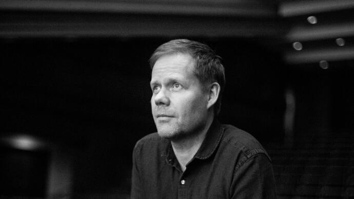 Black and white image of Max Richter in a music theatre, staring into the distance