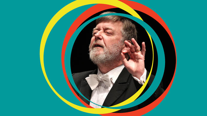 Sir Andrew Davis conducts, with green BBC SO branding around his centred image