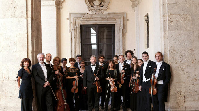 The members of Europa Galante standing in a line holding their instruments