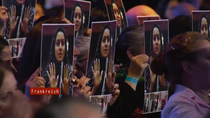 Women hold up the picture of a woman