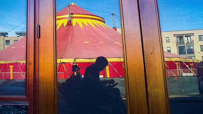 Reflected image in a window of a man in a wheelchair