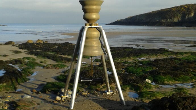 Photo of one of Marcus Vergette's Time and Tide bells on a beach at low tide