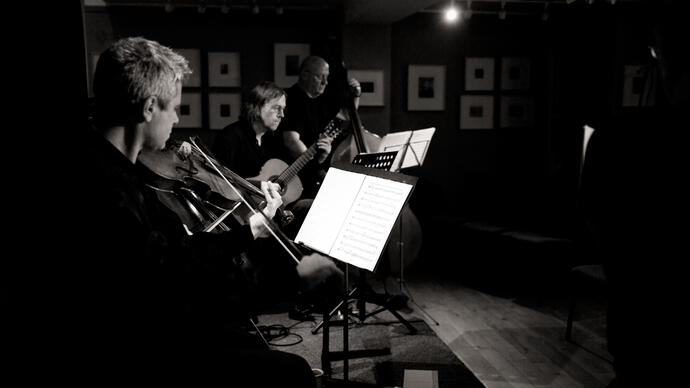 Black and white photo of musicians from the Gavin Bryars Ensemble