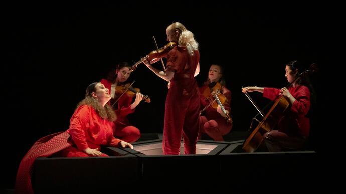 The Ragazze Quartet and Lucia Lucas dressed in red, performing The World's Wife on stage