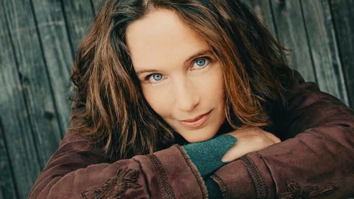 Close up photo of Helene Grimaud resting her head on her arms