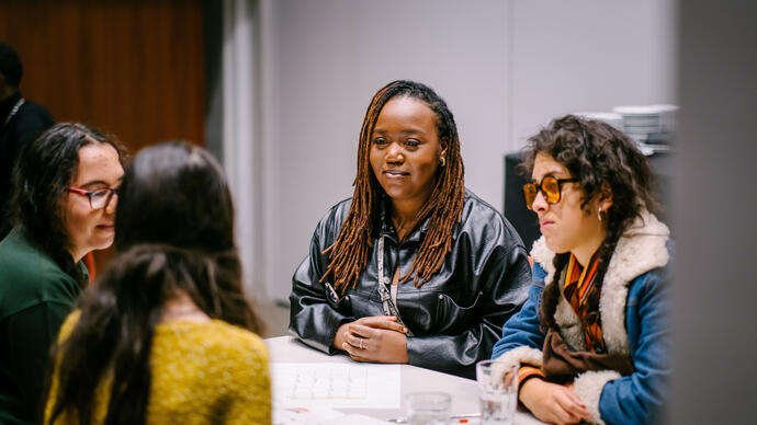 Four people having a discussion around a table