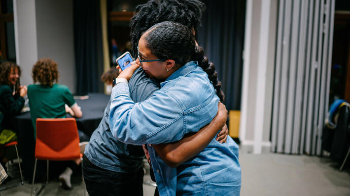 Two people embracing each other in the middle of the room