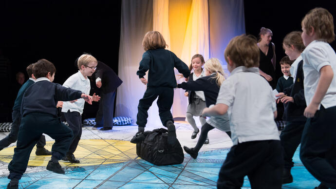A group of children play in The Pit theatre during a performance of Get Happy