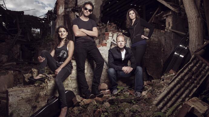 The Carducci Quartet sitting amongst the ruins of a brick building
