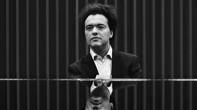 Black and white photo of Evgeny Kissin sitting at a piano