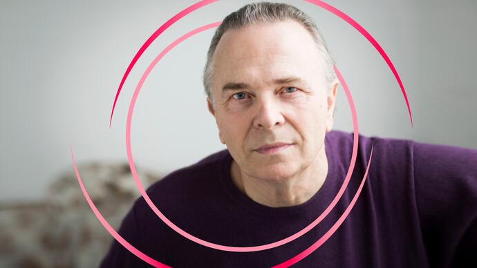 A photo of Mark Elder with pink circular swirls around him