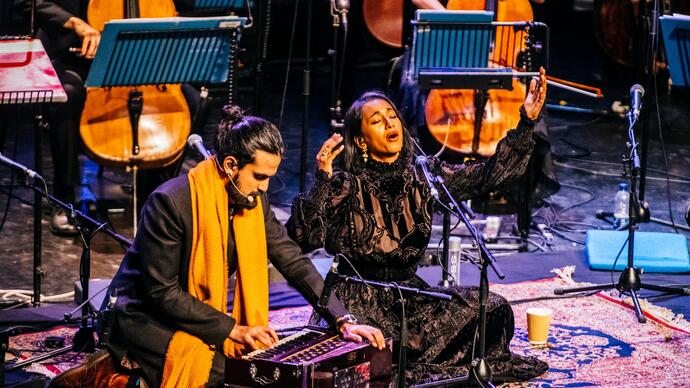 Rushil Ranjan and Abi Sampa sitting on stage performing