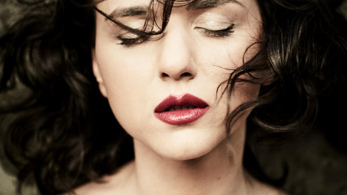 Close up shot of Khatia Buniatishvili with her eyes closed and her hair blowing in her face