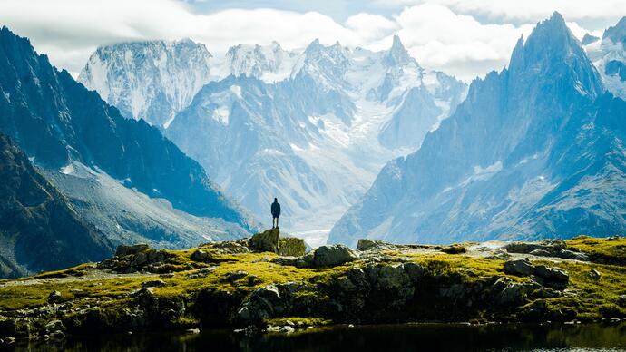 A man looking out at a vast mountainous landscape