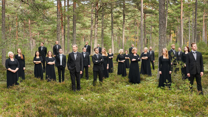 Estonian Philharmonic Chamber Choir standing in the forest