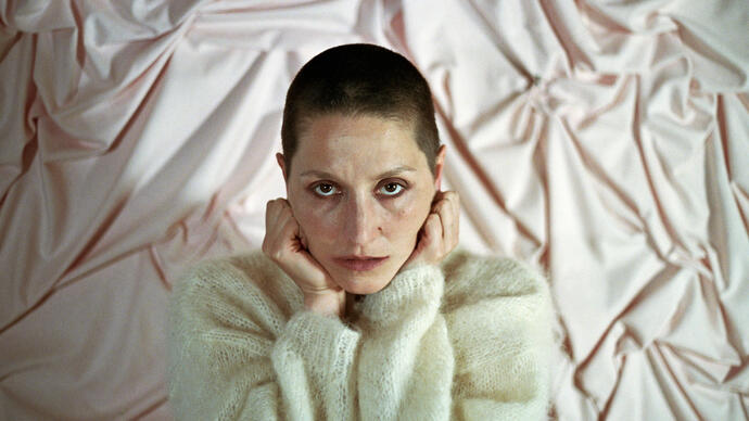 Cate Le Bon in front of a pink satin background
