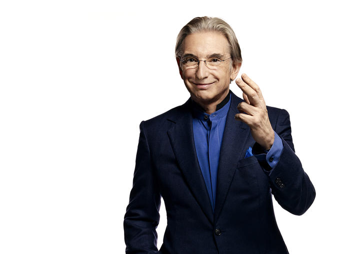 Photo of Michael Tilson Thomas wearing a black suit and blue shirt