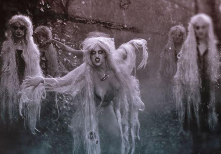 a black and white photo of women dressed as witches