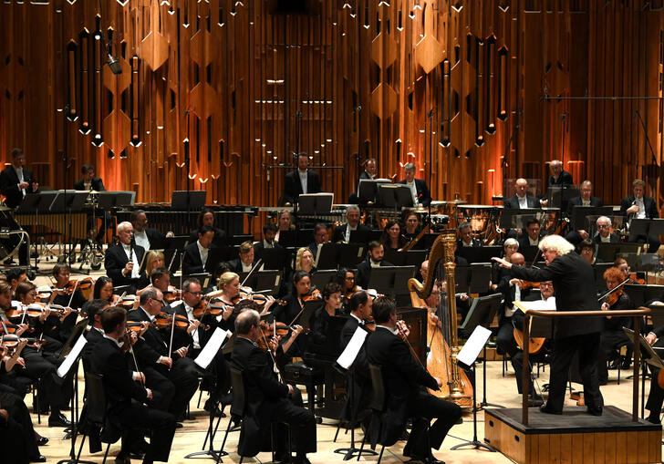 Photo of Sir Simon Rattle conducting the London Symphony Orchestra in the Barbican Hall