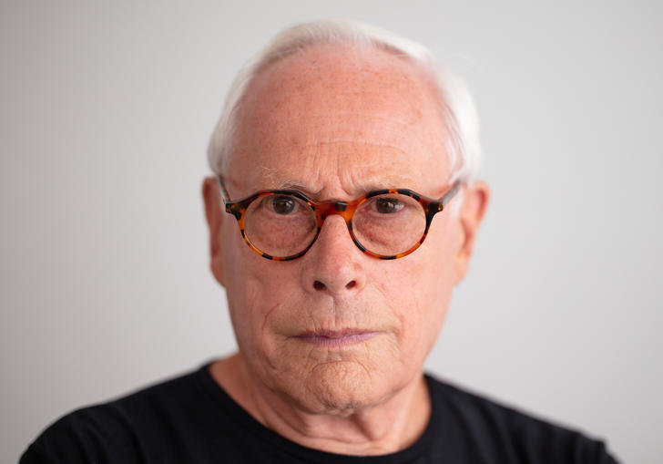 Dieter Rams is wearing a pair of tortoise shell spectacles and a black t-shirt 