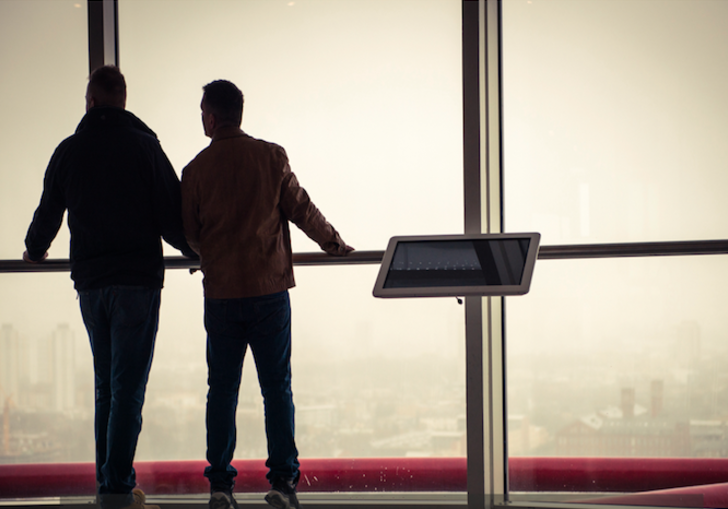 Two people looking out through glass