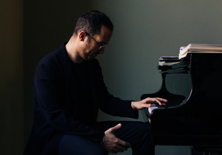 Igor Levit sitting at piano 