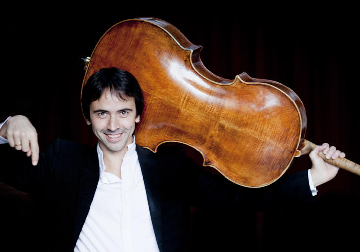Jean Guihen Queyras holding a cello over his head