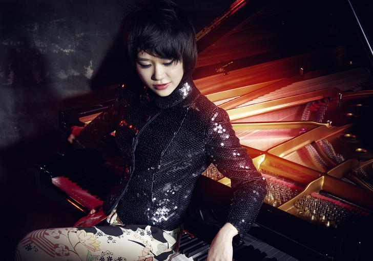 Yuja Wang sitting backwards at a piano