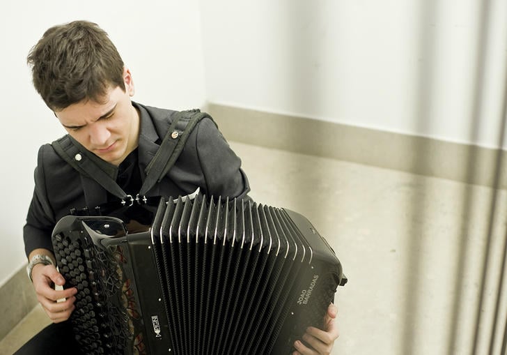 Joao Barradas playing accordion in stairwell