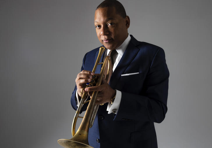 Wynton Marsalis wearing a suit, holdin his trumpet