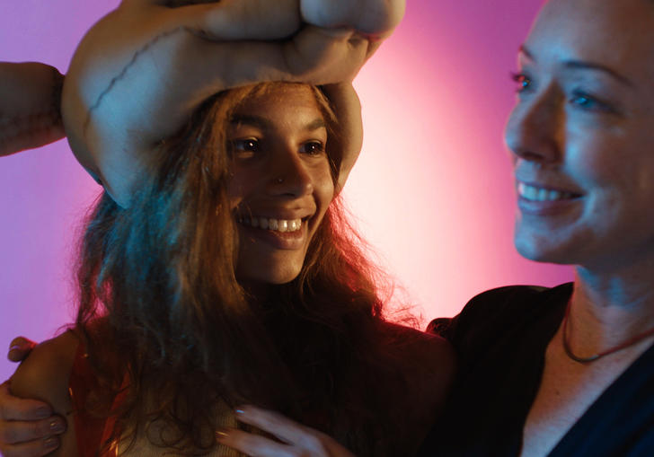 Lead actress Helena Howard in an animal hat, smiling in front of soft pink lighting.