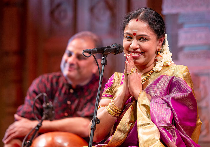 Sudha Ragunathan on stage, her hands are together in a demonstration of thanks