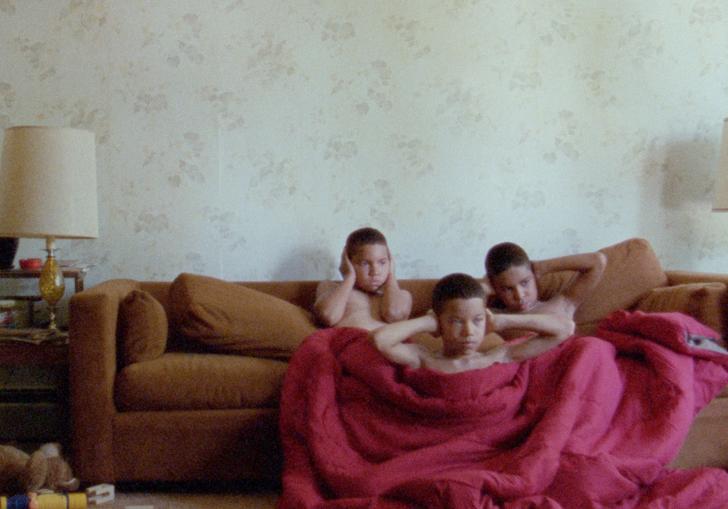 Boys sitting on a sofa covering their ears