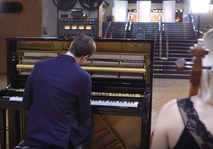 photo of erland cooper in front of a piano in the barbican foyer