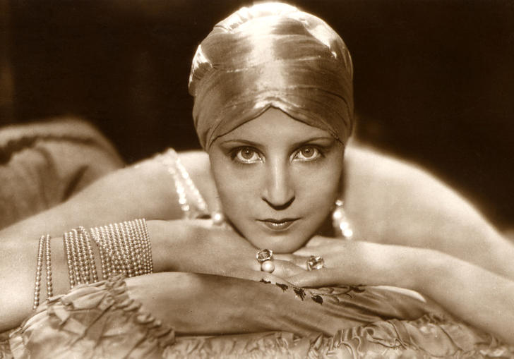 Brigitte Helm lying on a cushion with face resting upon her hands