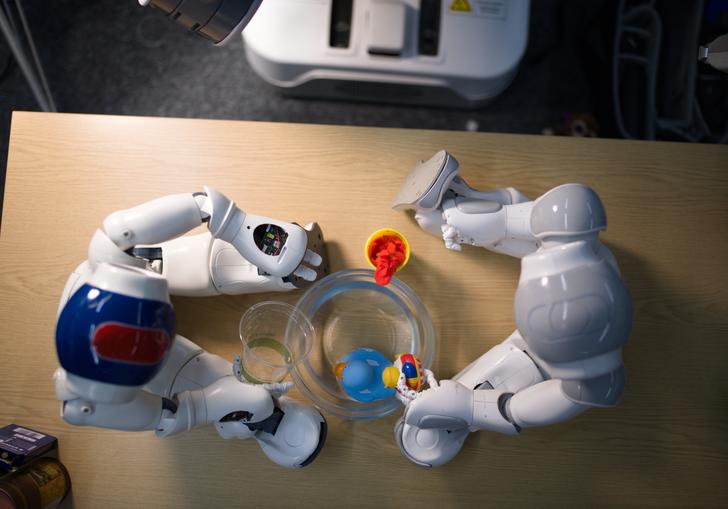 An aerial image of two toy robots sitting on a wooden table