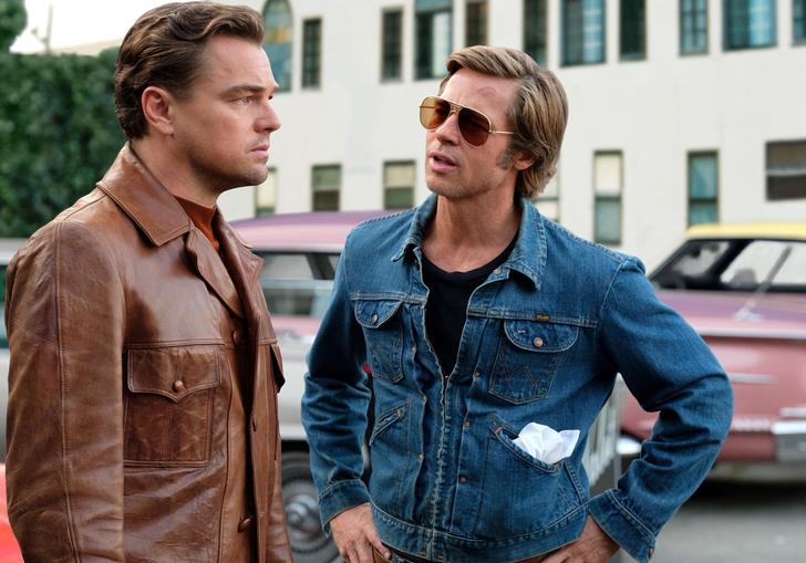 A teary eyed Leo Dicaprio talking to Brad Pitt in the street