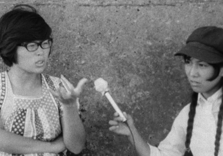 one women interviewing another in front of a wall