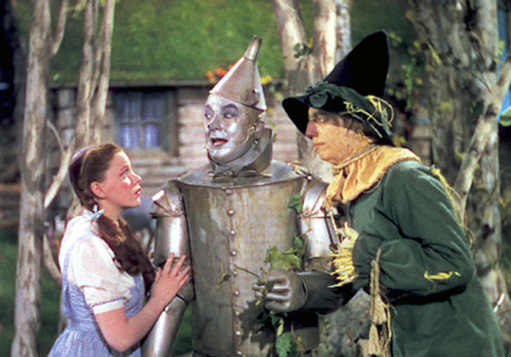 Dorothy, Tin Man and Scarecrow stand together in fear