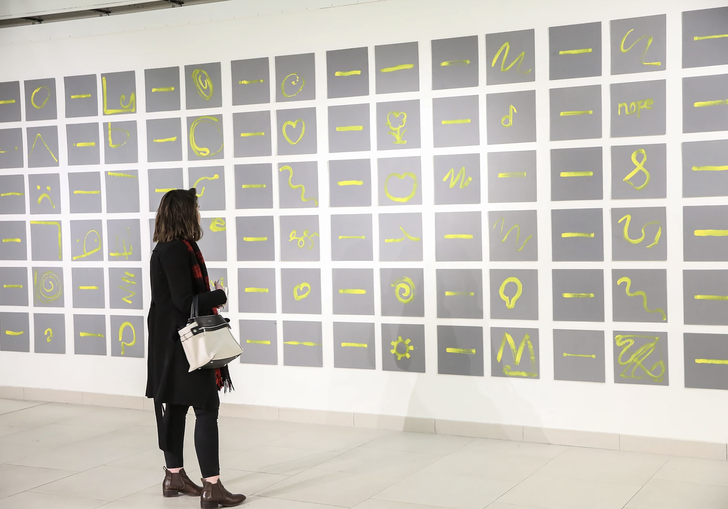 An image of a woman looking at Charles Harrison's Single Yellow Lines: exploring single and expressive gestures through paint with people with and without dementia. 2017. 