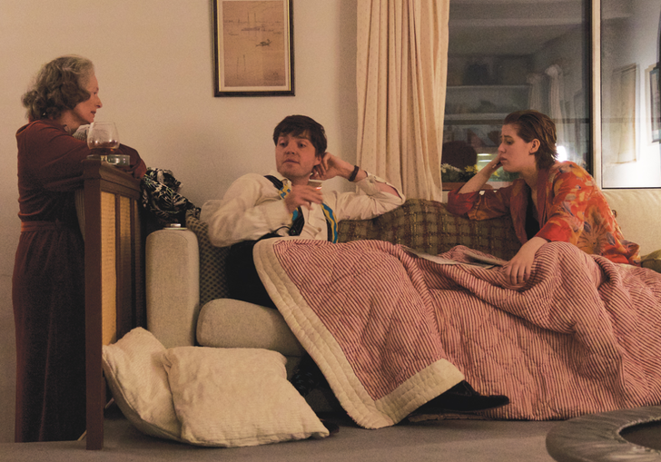 tilda swinton, honor swinton byrne, tom burke all sitting around a white sofa