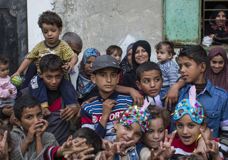 group of children and young people huddled together looking at the camera