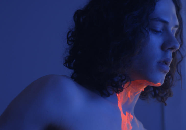 boy in dark room covered in neon paint
