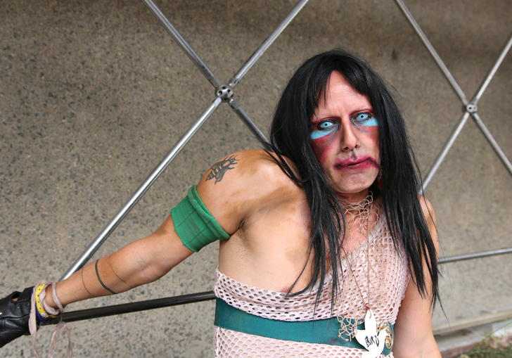 photo of CHRISTEENE posing against metal bars and a concrete background