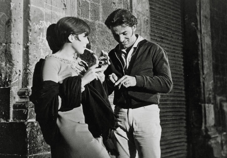 man and woman leaning against a wall at night