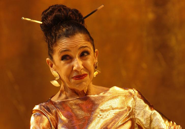 timon of athens standing in a stone room dressed in gold