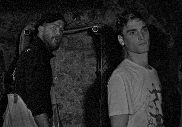 Two fishermen in some sort of cave